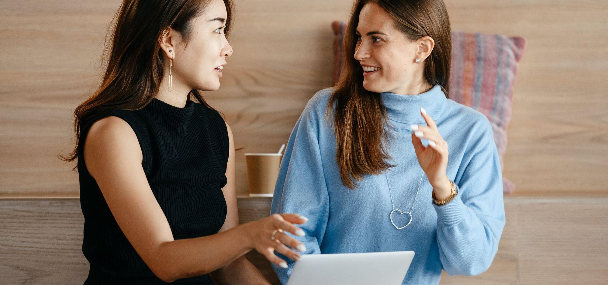 Zwei Frauen diskutieren darüber, ob sie Software entwickeln oder kaufen sollen 