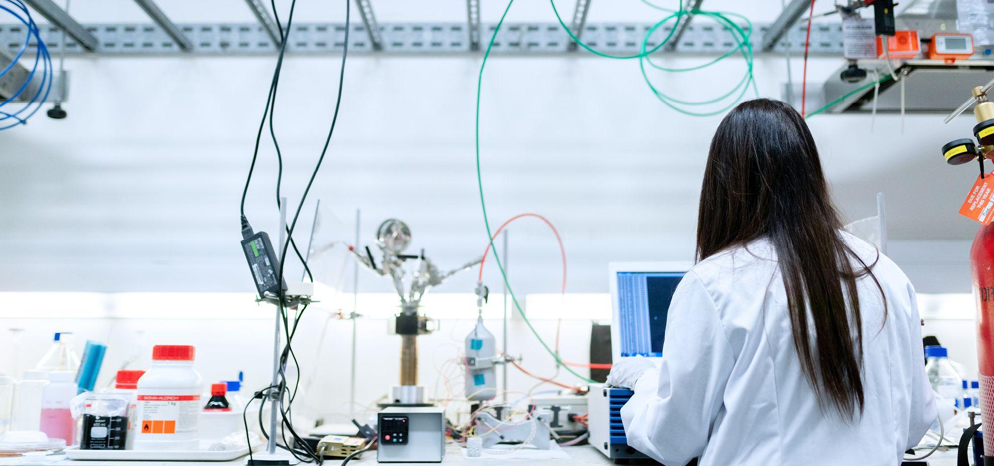 Lady in a lab conducting experiments for tech transfer process.