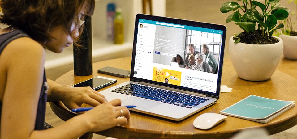 Picture of a woman taking notes and looking at how to create a website without coding with LoftOS' integrated website builder Pages
